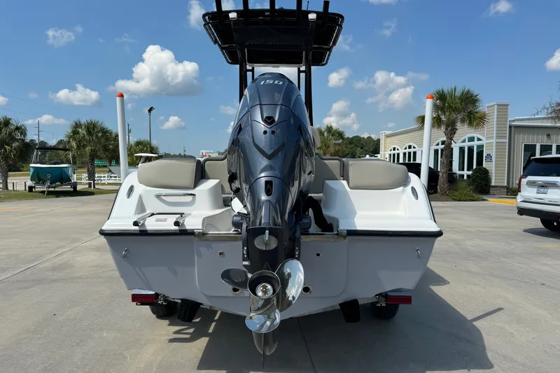 Slide: The Image of 2025 Key West 203 FS boat with outboard motor, parked outdoors on a sunny day. - 4