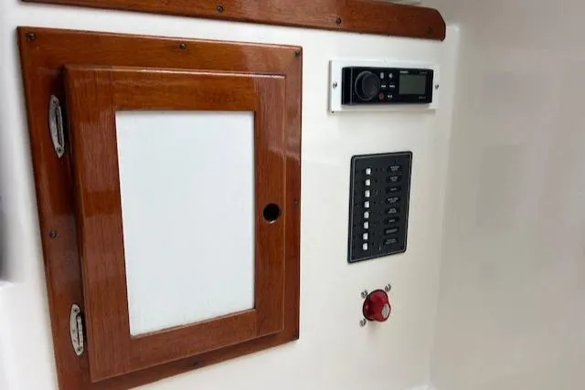 Slide: The Image of Control panel of 2004 Hunt Yachts Surfhunter 25 with wooden cabinet and electronic controls. - 13
