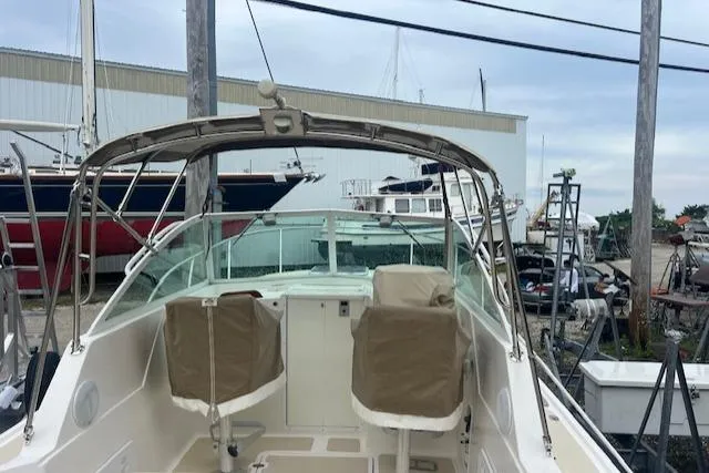 Slide: The Image of 2004 Hunt Yachts Surfhunter 25 boat with covered seats in a marina setting. - 22