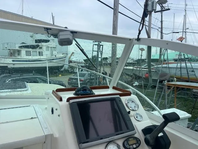 Slide: The Image of 2004 Hunt Yachts Surfhunter 25 helm with navigation equipment, docked near other boats. - 20