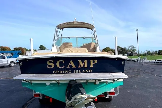 Slide: The Image of 2004 Hunt Yachts Surfhunter 25 boat named "Scamp" at a marina. - 4