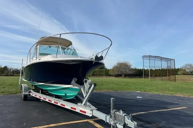 Slide: The Image of 2004 Hunt Yachts Surfhunter 25 on trailer, parked outdoors under clear sky. - 9