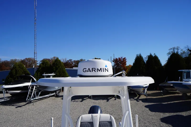 Slide: The Image of 2018 Tidewater 210 LXF boat with Garmin radar, parked outdoors under clear blue sky. - 18