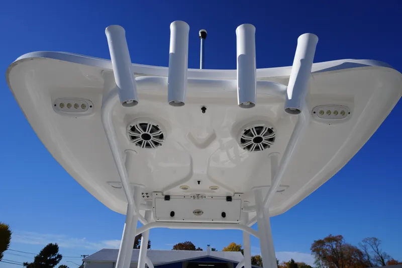Slide: The Image of 2018 Tidewater 210 LXF boat T-top with rod holders and speakers against blue sky. - 39
