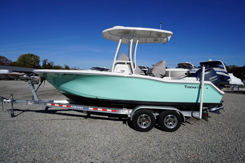 Slide: The Image of 2018 Tidewater 210 LXF boat on trailer, light blue hull, parked outdoors. - 58