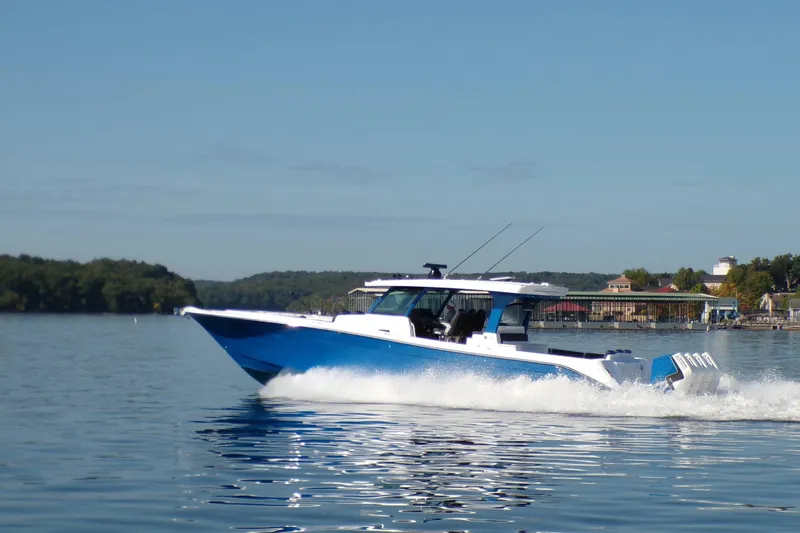 The Image of 2025 HCB 48 Campeon boat cruising on a calm lake under clear skies. - 0