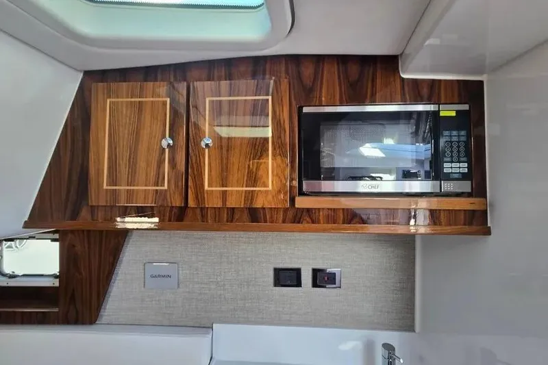 Slide: The Image of 2025 HCB 48 Campeon interior with wood cabinets and built-in microwave. - 17