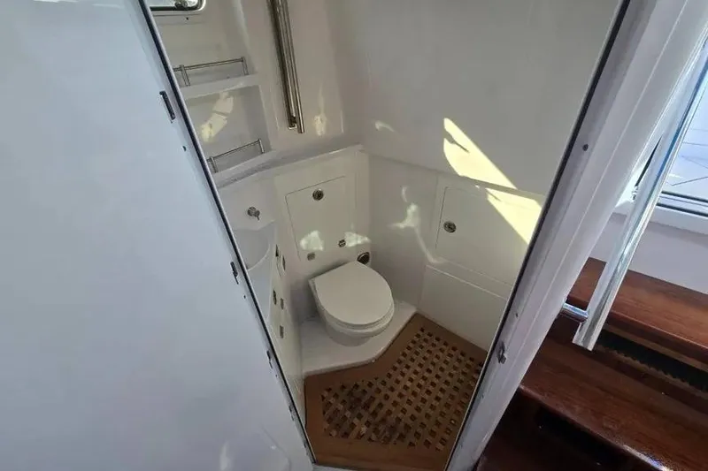 Slide: The Image of 2025 HCB 48 Campeon boat bathroom with toilet and wooden floor accents. - 19