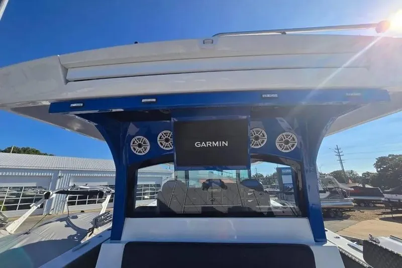 Slide: The Image of 2025 HCB 48 Campeon boat with Garmin display and speakers, docked under clear blue sky. - 22