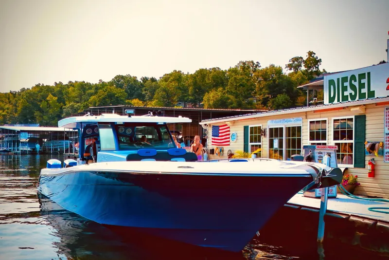 Slide: The Image of 2025 HCB 48 Campeon boat docked at a lakeside fuel station. - 4