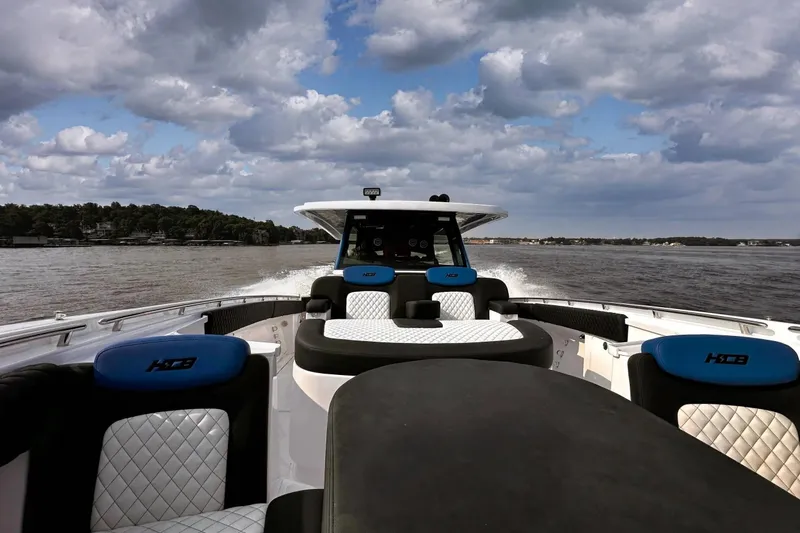 Slide: The Image of 2025 HCB 48 Campeon boat cruising on a lake under a cloudy sky. - 5