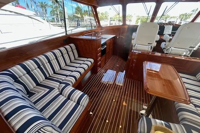 Slide: The Image of Luxurious interior of 2024 Hinckley Talaria 43 MY yacht with striped seating and wooden finishes. - 2