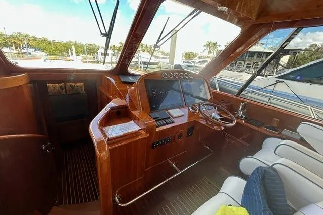 Slide: The Image of 2024 Hinckley Talaria 43 MY yacht interior with polished wood and modern navigation equipment. - 3