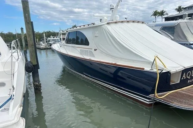 Slide: The Image of 2024 Hinckley Talaria 43 MY yacht docked in marina, covered, with calm water and cloudy sky. - 8