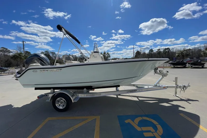 Slide: The Image of 2026 Key West 203 FS boat on trailer under a clear blue sky. - 4