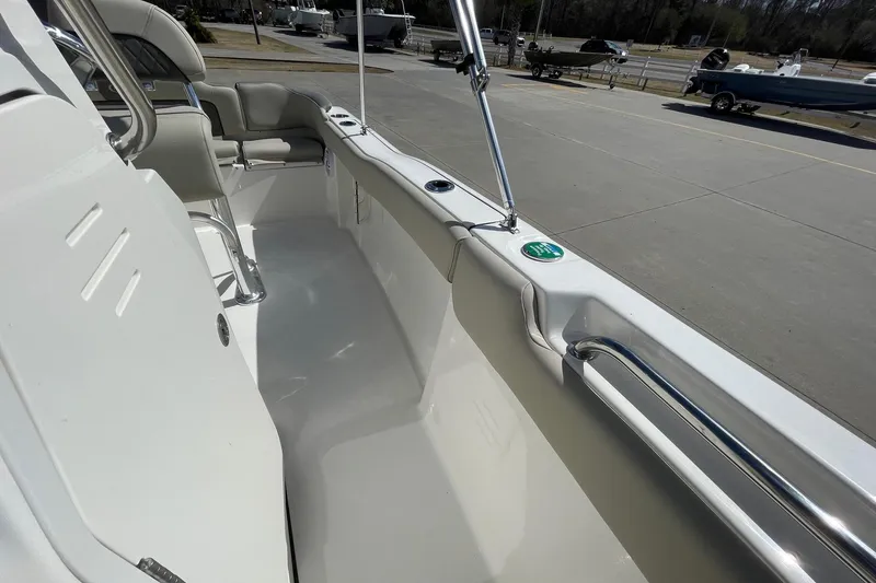 Slide: The Image of 2026 Key West 203 FS boat interior with seating and railing, parked on concrete. - 15