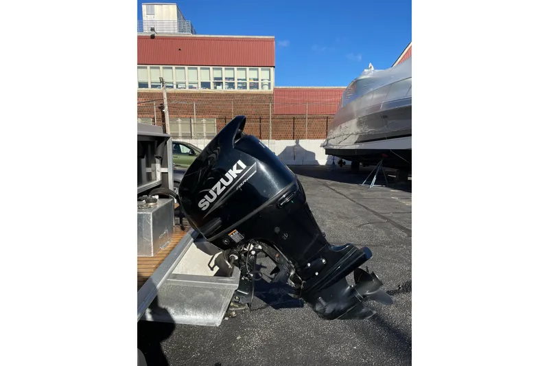 Slide: The Image of 2013 Sylvan Mirage Cruise 8520 CR with Suzuki outboard motor in a parking lot. - 7