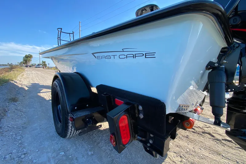 Slide: The Image of 2024 East Cape EVO 18V boat on trailer, parked on a sunny dirt road. - 11