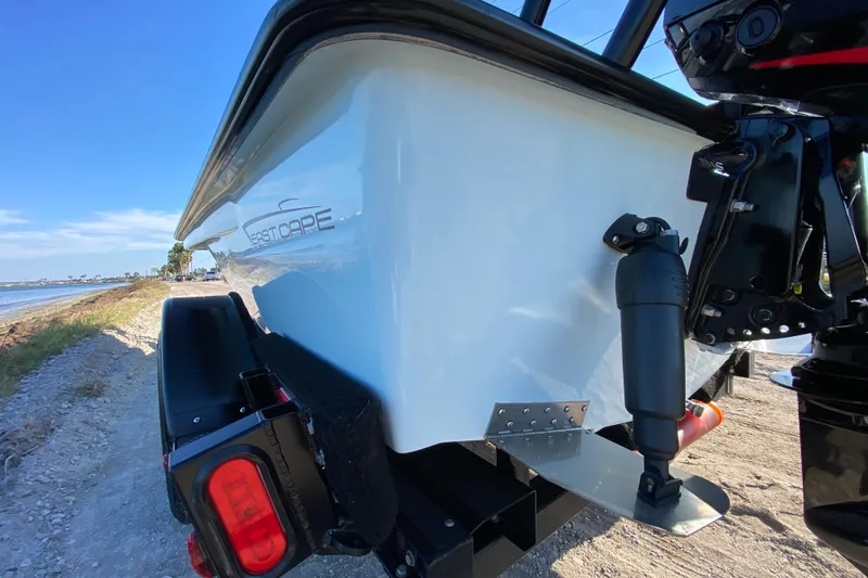 Slide: The Image of 2024 East Cape EVO 18V boat on trailer by the shoreline, showcasing sleek design. - 12