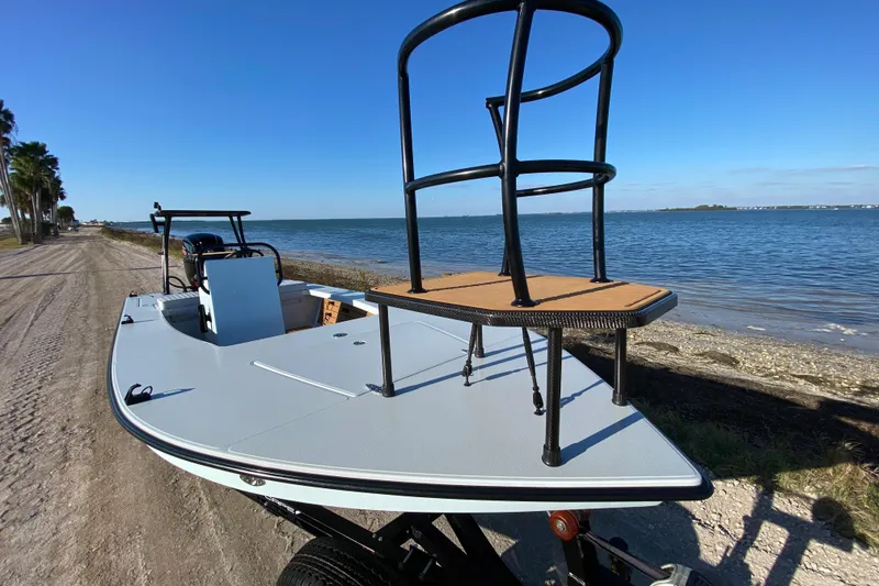 Slide: The Image of 2024 East Cape EVO 18V boat by the shoreline, featuring a raised platform. - 21