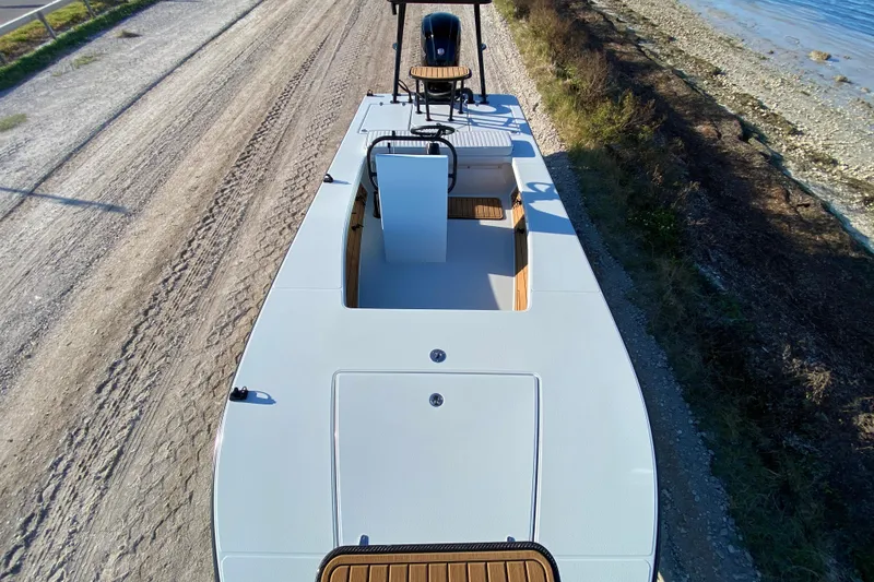 Slide: The Image of 2024 East Cape EVO 18V boat on a coastal road, showcasing sleek design and spacious deck. - 24