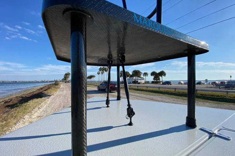 Slide: The Image of 2024 East Cape EVO 18V boat on coastal road with palm trees and ocean view. - 26