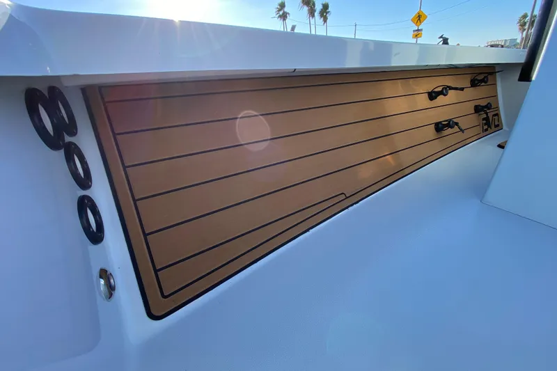Slide: The Image of 2024 East Cape EVO 18V boat interior with sleek wood paneling and rod holders. - 33