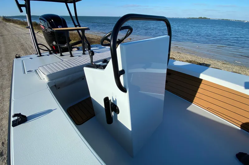 Slide: The Image of 2024 East Cape EVO 18V boat interior with steering console by the shoreline. - 36