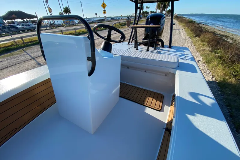 Slide: The Image of 2024 East Cape EVO 18V boat interior with seating, steering, and coastal view. - 37