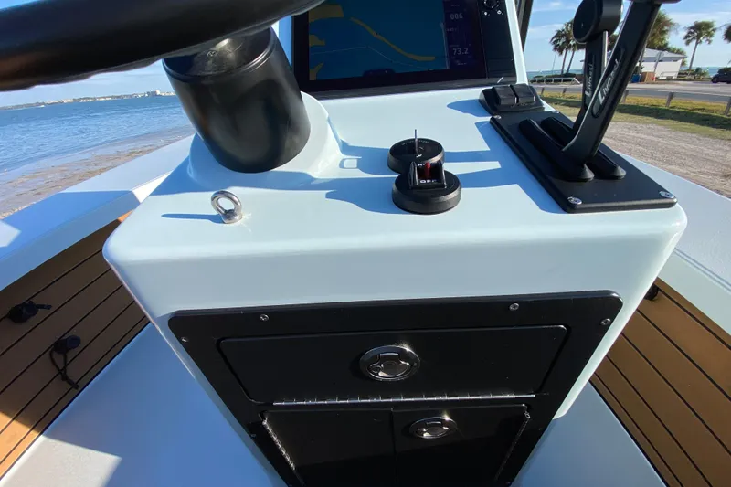 Slide: The Image of 2024 East Cape EVO 18V boat console with steering wheel and controls by the water. - 42