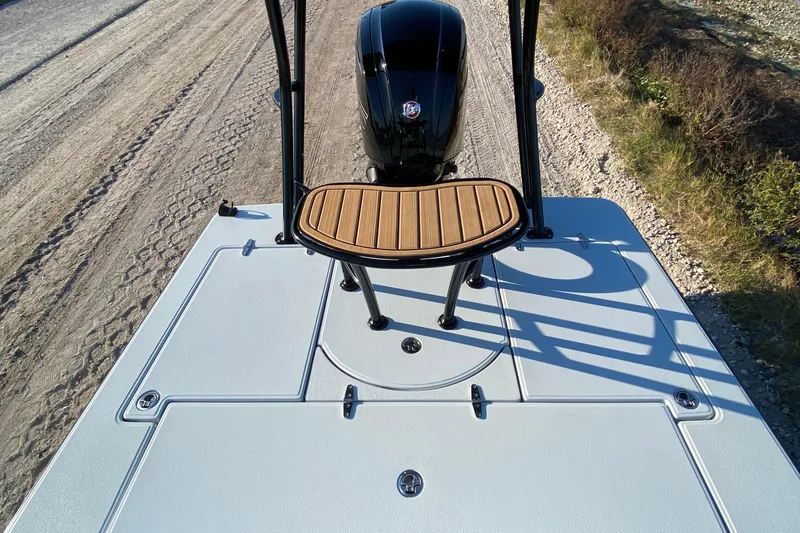 Slide: The Image of 2024 East Cape EVO 18V boat deck with motor and wooden seat. - 49