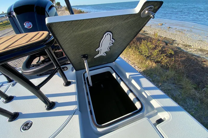 Slide: The Image of 2024 East Cape EVO 18V boat with open storage compartment by the water. - 58