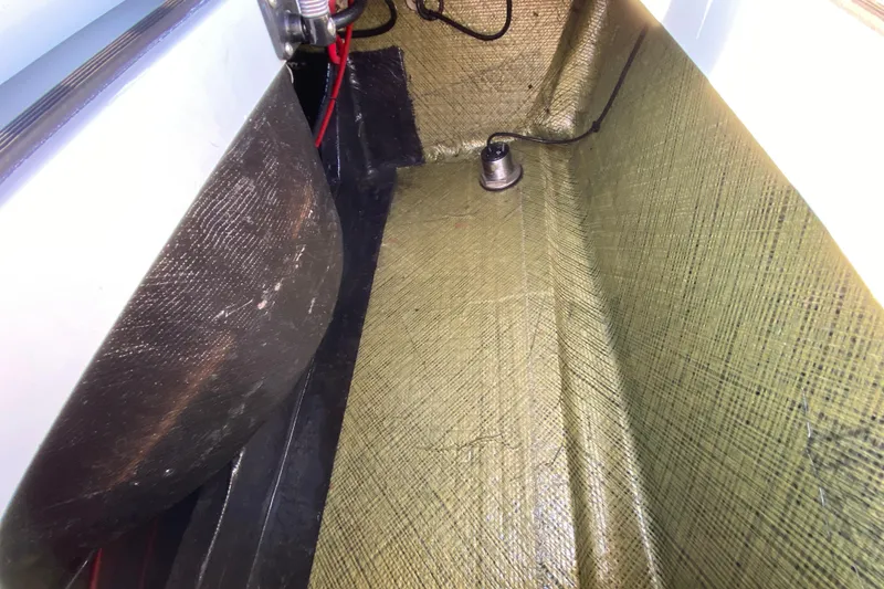 Slide: The Image of Interior view of 2024 East Cape EVO 18V boat, showcasing wiring and textured flooring. - 59