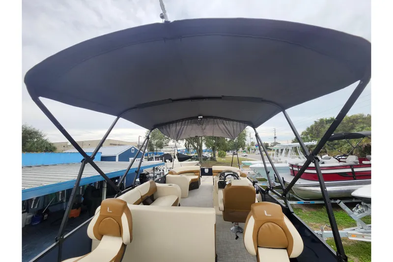 Slide: The Image of 2026 Lowe SF 212 Sport Fish pontoon boat with canopy and seating, docked outdoors. - 33