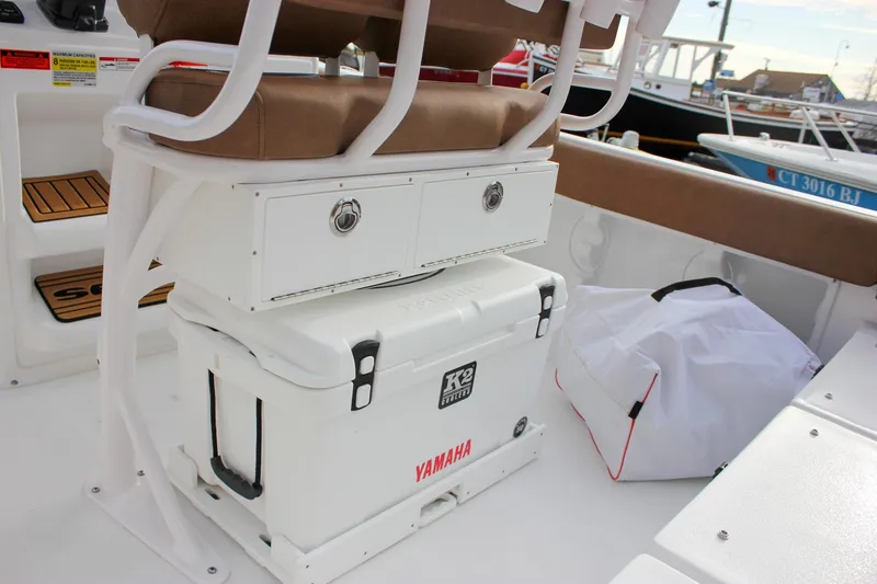Slide: The Image of 2026 Sea Hunt Ultra 219 boat interior with seating, storage, and cooler. - 15