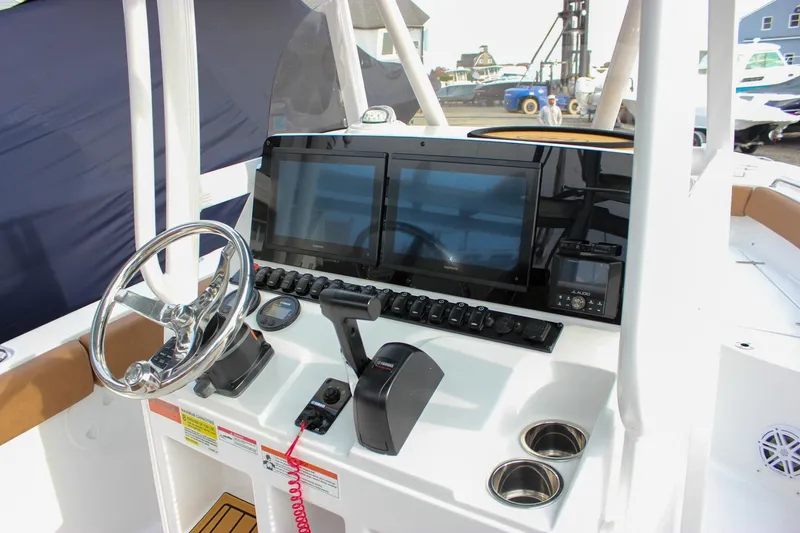 Slide: The Image of 2026 Sea Hunt Ultra 219 boat dashboard with steering wheel, dual screens, and control panel. - 19
