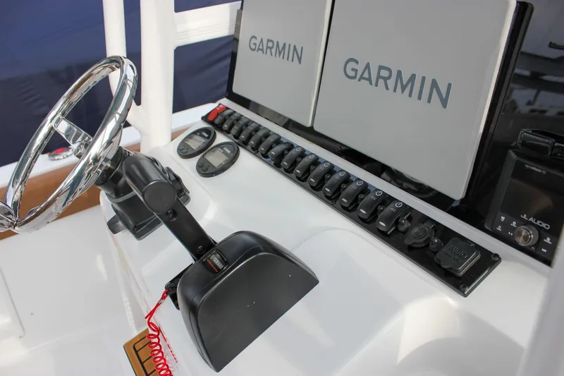 Slide: The Image of 2026 Sea Hunt Ultra 219 boat dashboard with Garmin displays and controls. - 22