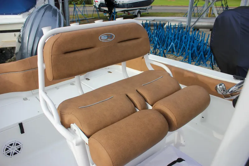 Slide: The Image of 2026 Sea Hunt Ultra 219 boat with tan cushioned seating and white frame. - 23