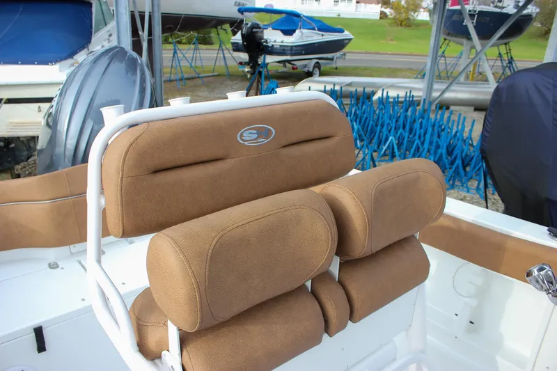 Slide: The Image of 2026 Sea Hunt Ultra 219 boat with brown cushioned seating and white frame. - 24