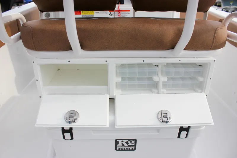 Slide: The Image of 2026 Sea Hunt Ultra 219 boat storage compartments with brown cushioned seating. - 34
