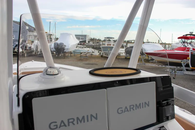 Slide: The Image of 2026 Sea Hunt Ultra 219 boat dashboard with Garmin navigation system in a marina setting. - 36