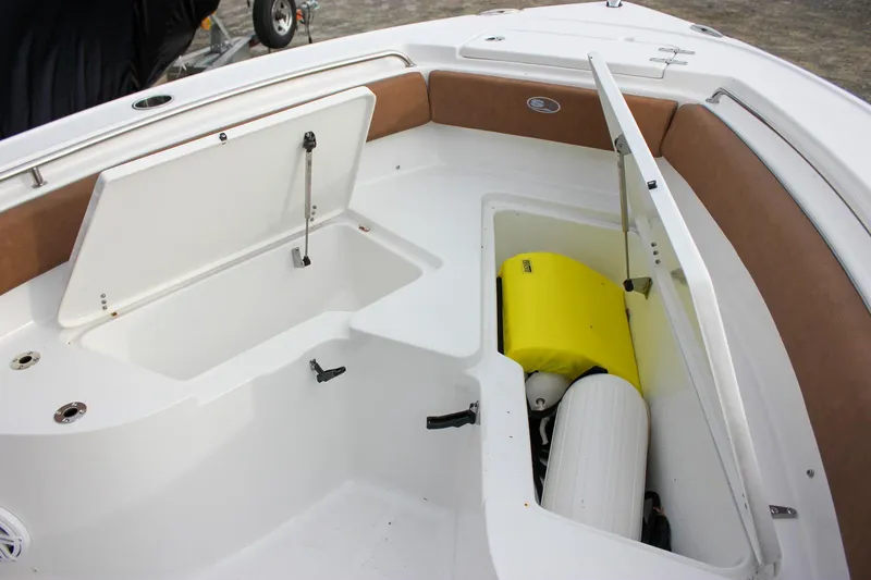 Slide: The Image of 2026 Sea Hunt Ultra 219 boat storage compartments with open hatches, showcasing interior space. - 38
