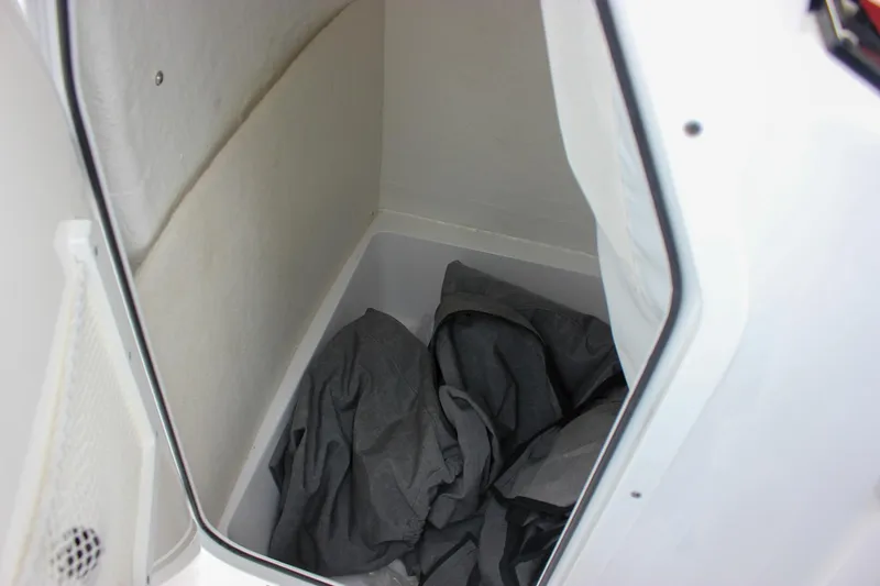 Slide: The Image of Storage compartment in 2026 Sea Hunt Ultra 219 boat, featuring interior space and fabric items. - 44