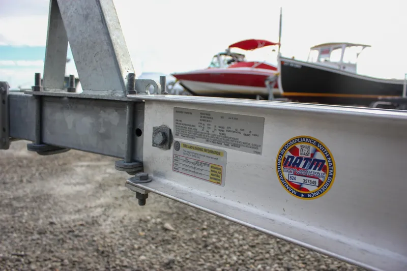 Slide: The Image of Trailer with compliance sticker, Sea Hunt Ultra 219 boats in background, 2026 model. - 48