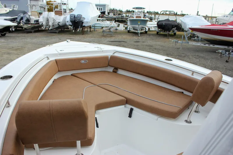 Slide: The Image of 2026 Sea Hunt Ultra 219 boat interior with tan seating, docked among other boats. - 6