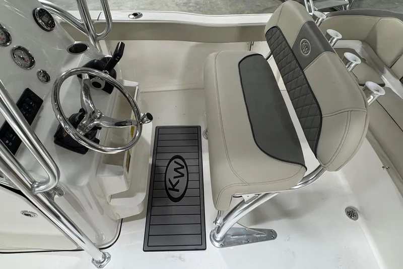 Slide: The Image of 2026 Key West 203 FS boat interior with steering wheel and cushioned seating. - 11