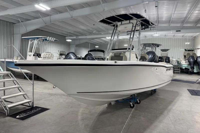 Slide: The Image of 2026 Key West 203 FS boat in showroom, sleek design, white exterior, modern features. - 2