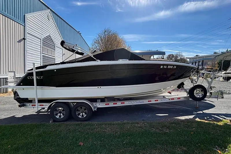 Slide: The Image of 2021 Cobalt R6 boat on trailer, parked outdoors near a building. - 2