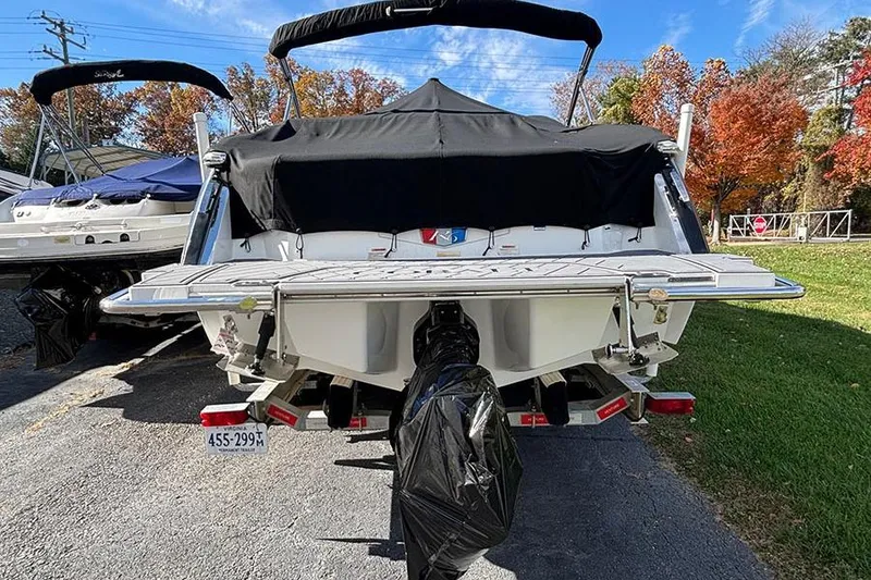 Slide: The Image of 2021 Cobalt R6 boat with black cover, parked outdoors in autumn setting. - 4