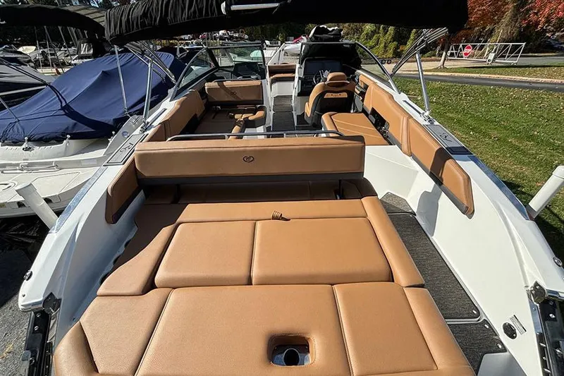 Slide: The Image of 2021 Cobalt R6 boat with tan seating, docked near covered boats. - 6